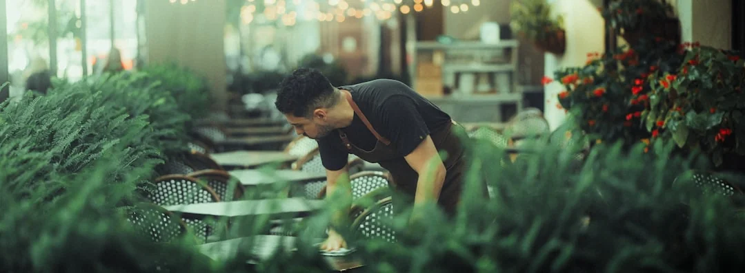 An adult male cleaning a glass window indoors, focusing on household chores and cleanliness.
